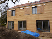 Façade en bardage mélèze avec système de volet coulissant en mélèze . facì§ade meìleìze maison bois